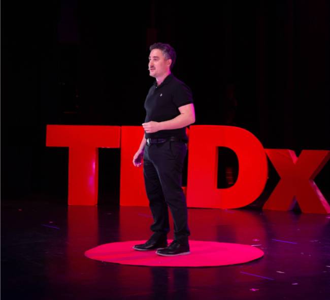 Francisco Santolo en TEDx - speaker internacional dando conferencia sobre innovación y emprendimiento en escenario TEDx